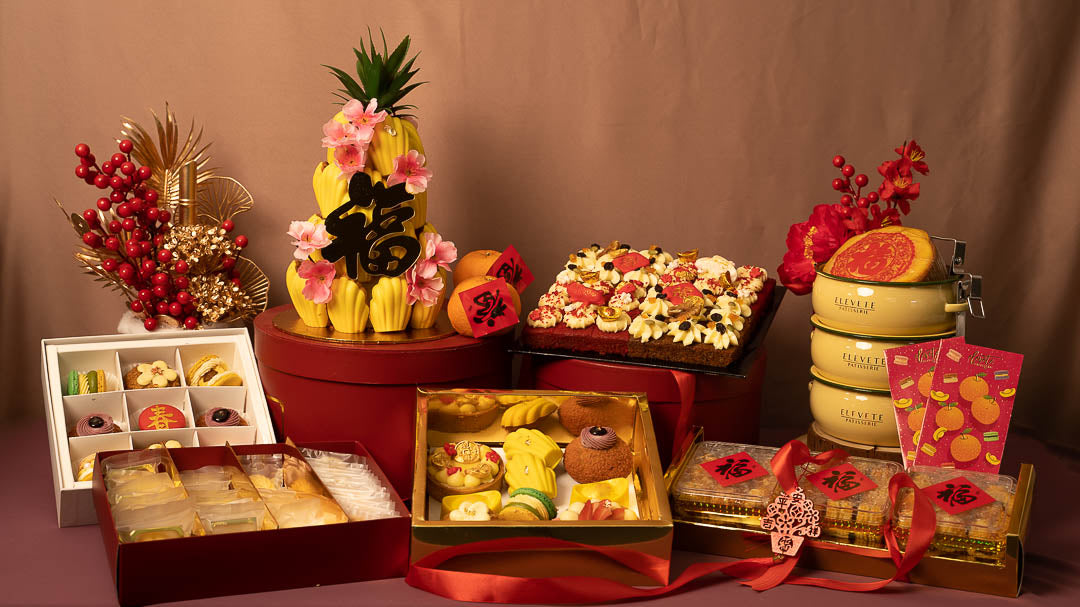 Chinese New Year hamper display with pineapple tower, tiered gift boxes and cookie tins — Elevete Patisserie