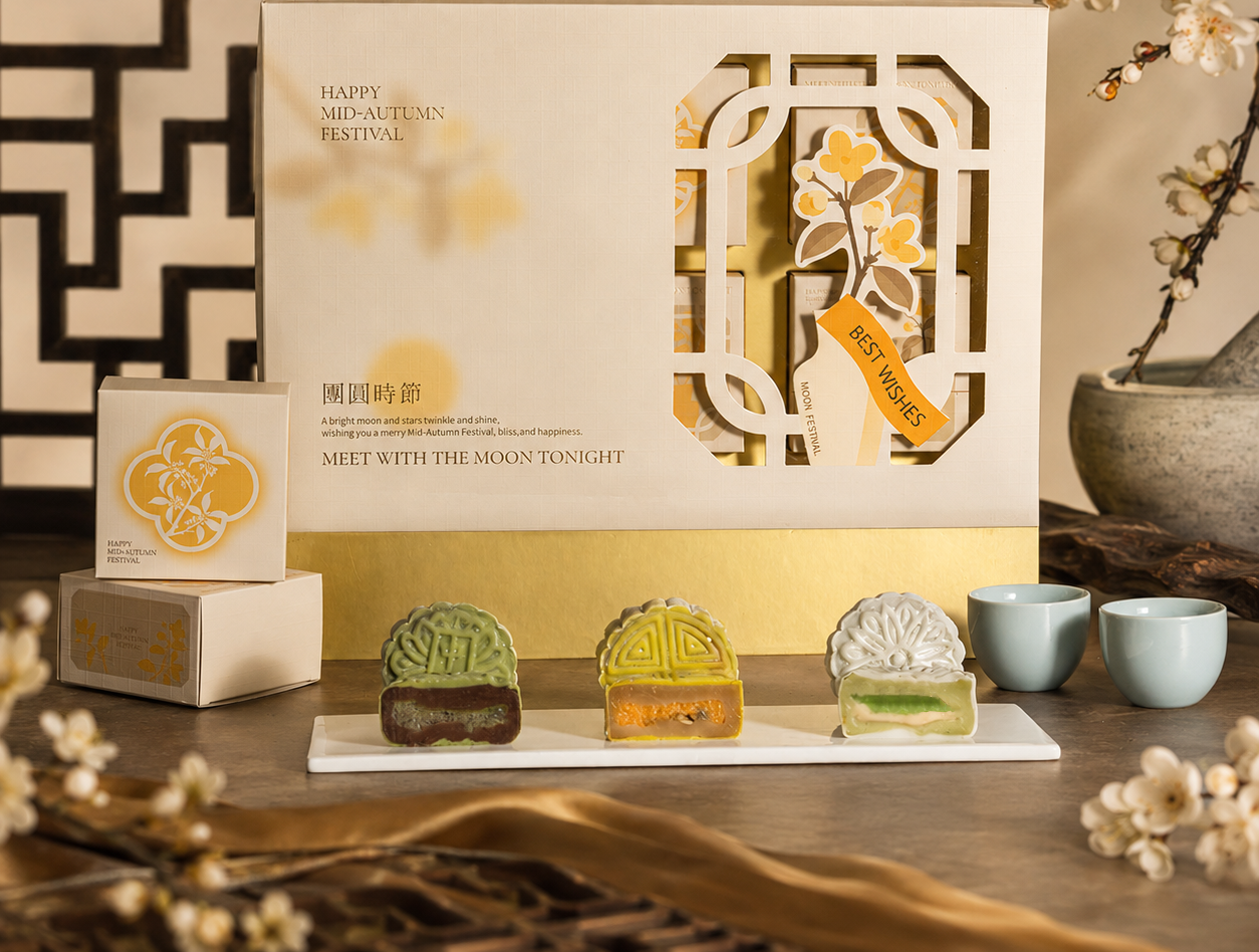 Snowskin mooncake gift box with three mooncakes cut open on a tray beside tea cups — Elevete Patisserie KL
