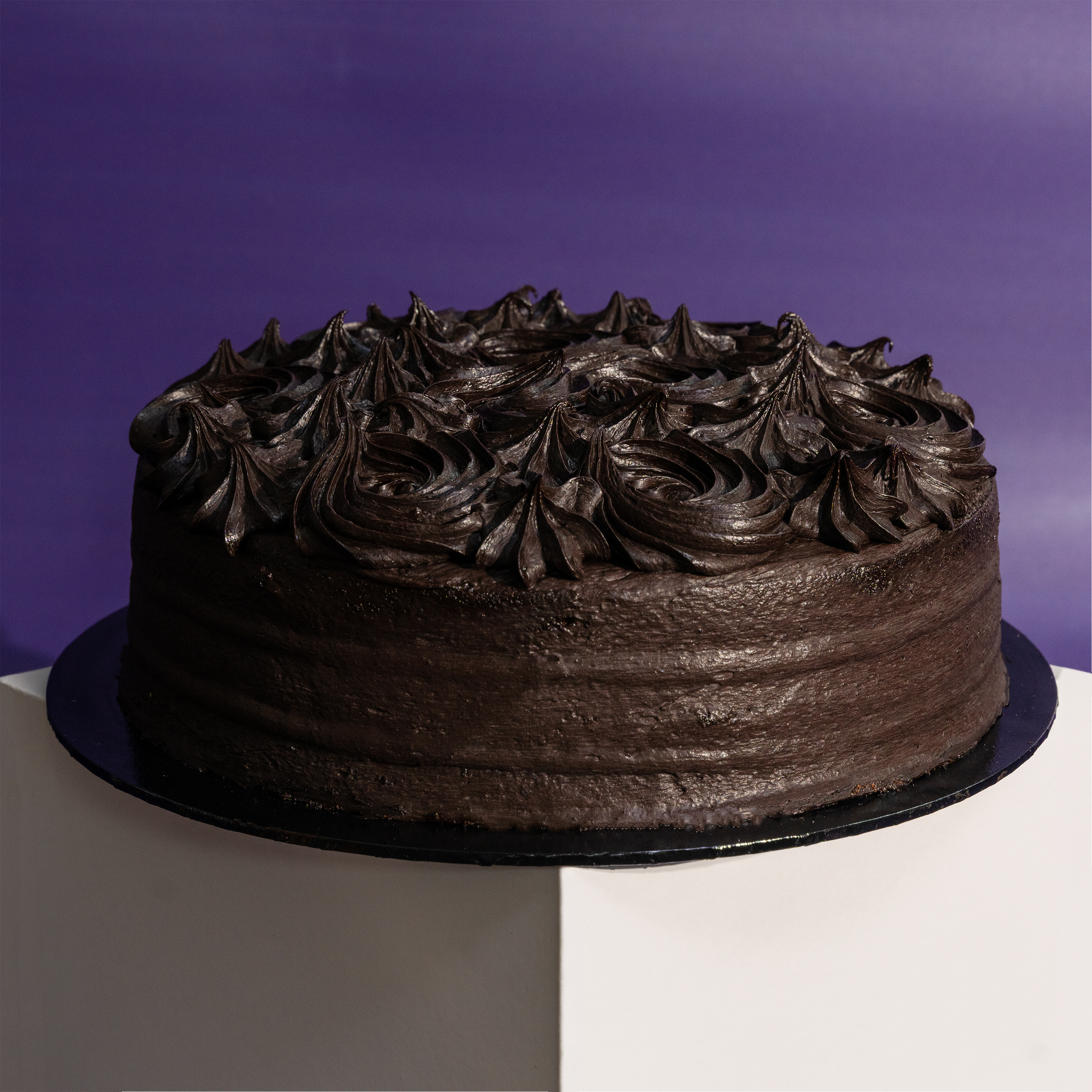 Whole round dark chocolate cake finished with piped rosettes — Elevete Patisserie KL