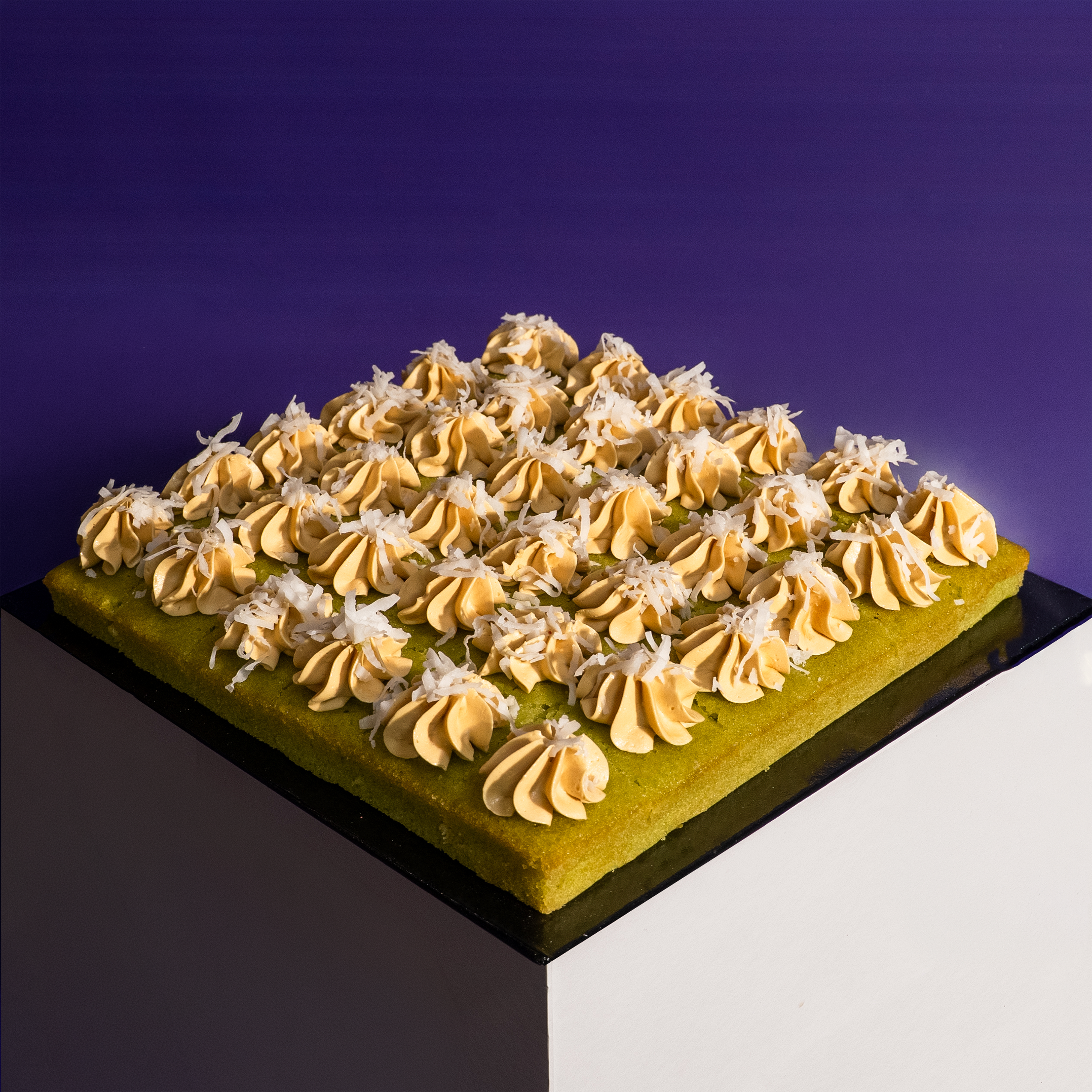 Square pandan gula melaka cake bites on a board, cut into shareable portions — Elevete Patisserie