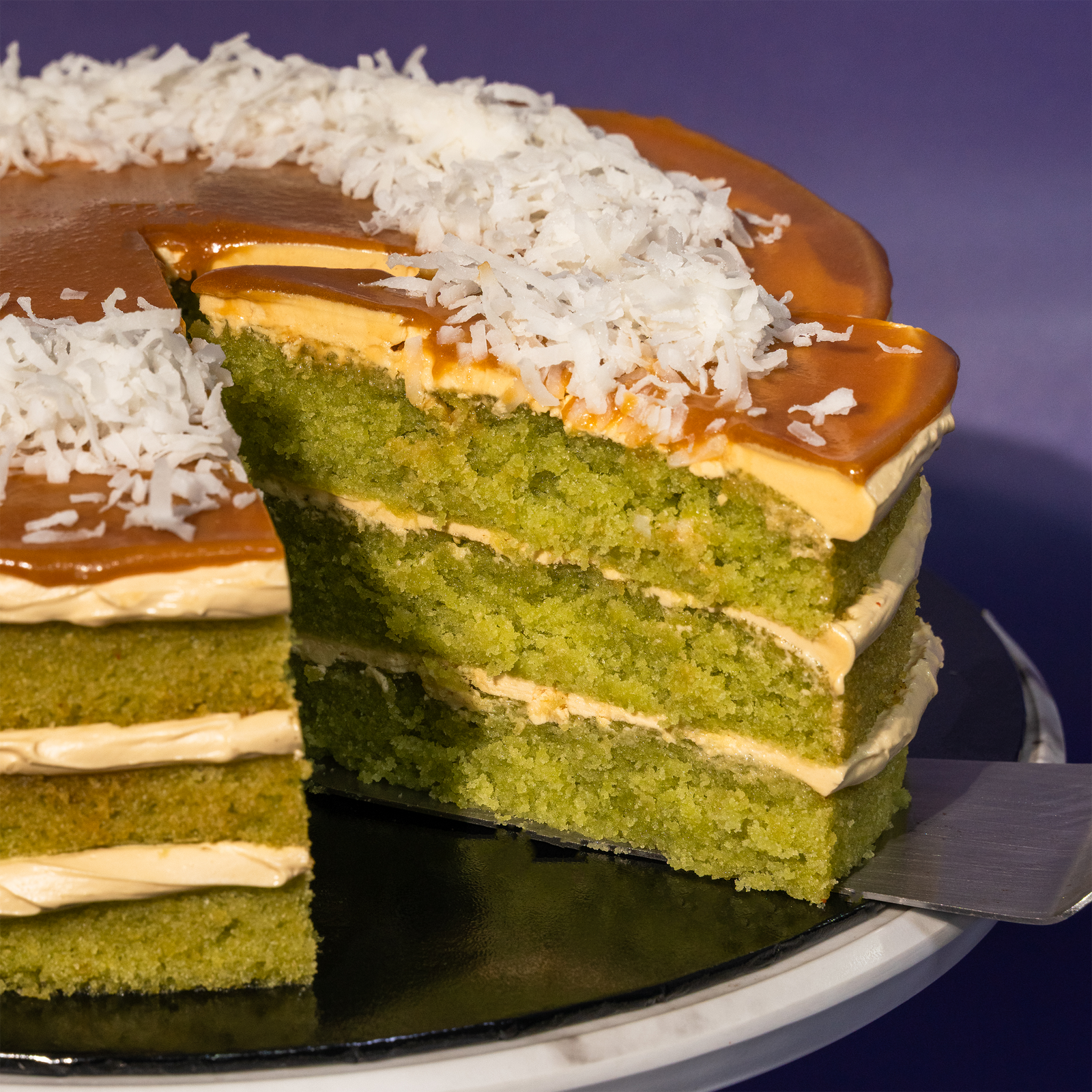 The Locale cake cut through, showing layers of pandan sponge with gula melaka buttercream between them — Elevete Patisserie