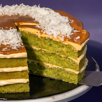 The Locale cake cut through, showing layers of pandan sponge with gula melaka buttercream between them — Elevete Patisserie
