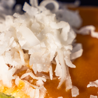 Macro detail of fresh shredded coconut scattered over glossy gula melaka glaze — Elevete Patisserie