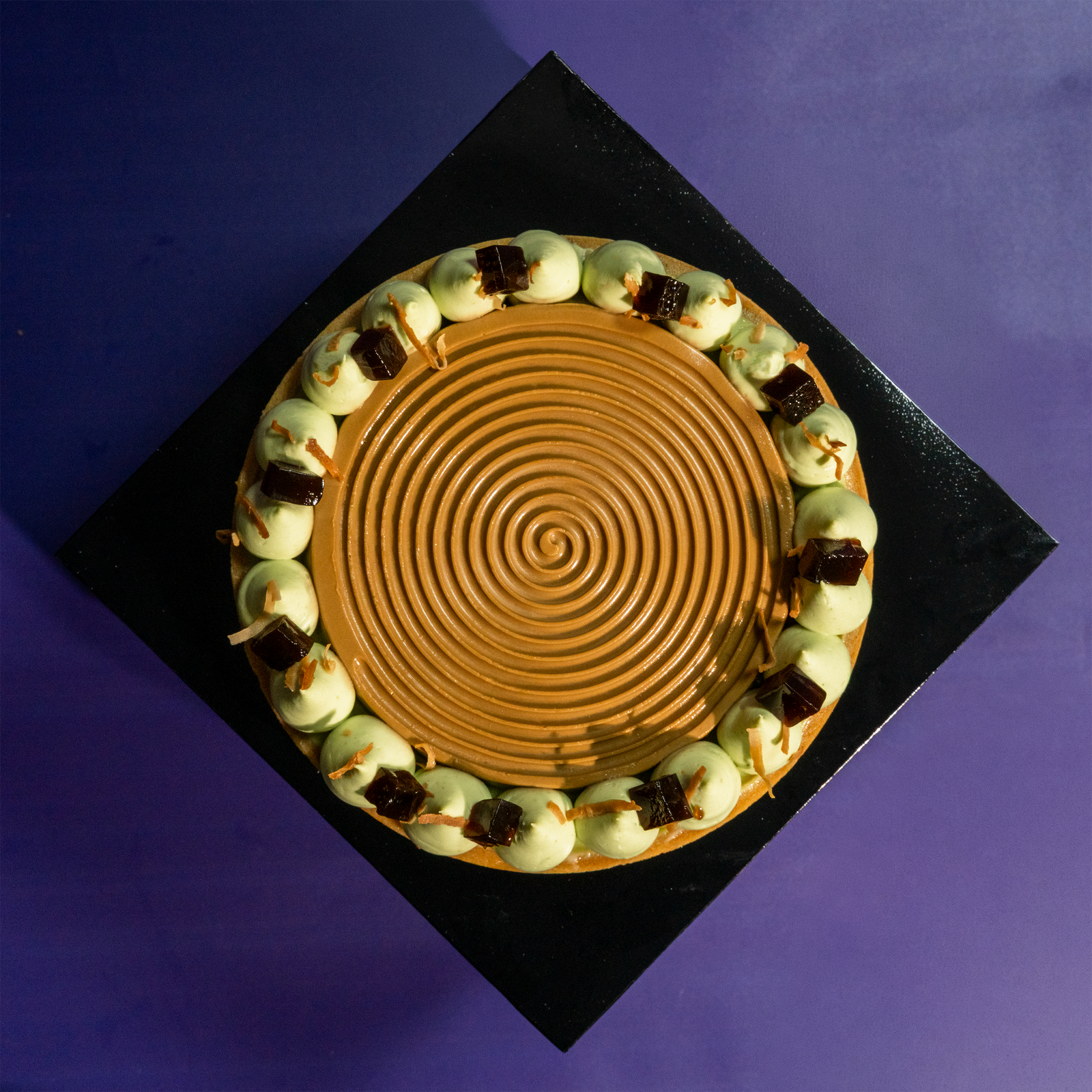 Pandan coffee tart from above, coffee spiral centre with pandan cream around the rim — Elevete Patisserie
