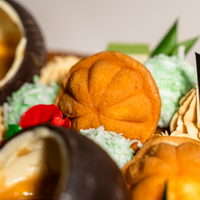 Close-up of kuih bahulu and coconut-coated ondeh-ondeh truffles on the Muhibbah Merdeka cake